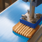 Multi-Head Sauce Depositor applying parallel lines of mayonnaise onto a slice of bread on a blue conveyor belt.