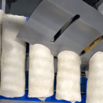 Ultrasonic wrap cutter slicing wraps at a 45-degree angle on a conveyor line.