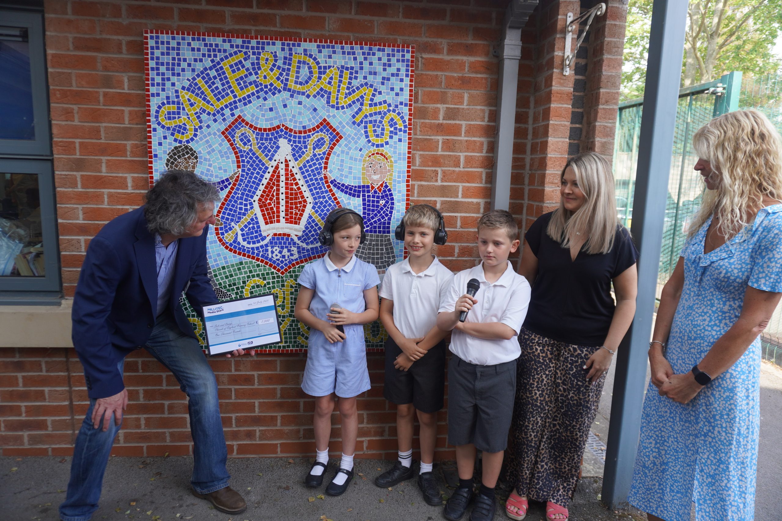 Sale & Davys prize presentation Millitec Managing Director Richard Ledger presenting a prize to three students from Sale & Davys C of E Primary School for winning the Media Starz radio competition.